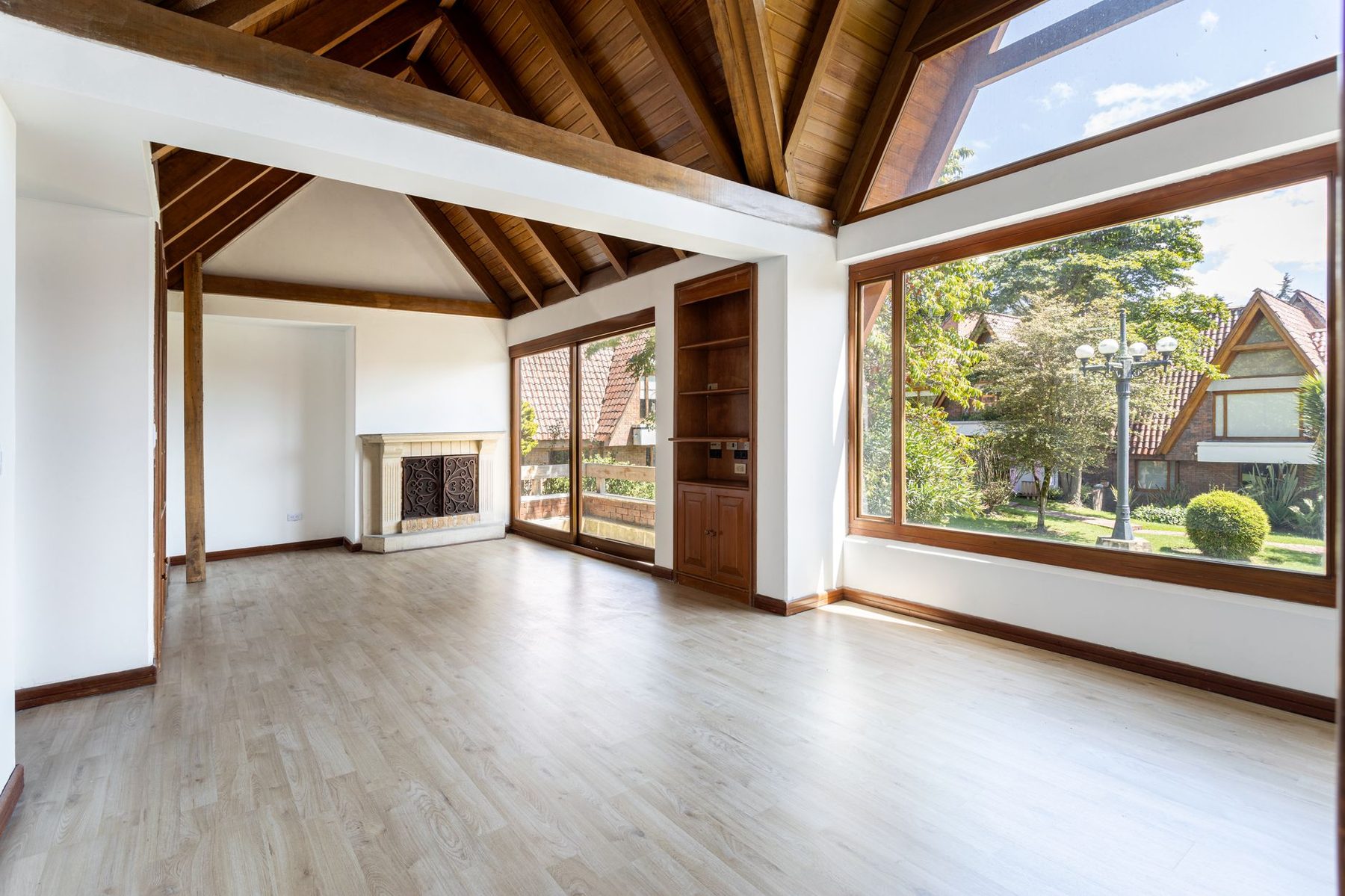 Interior de madera con grandes ventanales y vista a la naturaleza, diseñado por FAMA Arquitectos